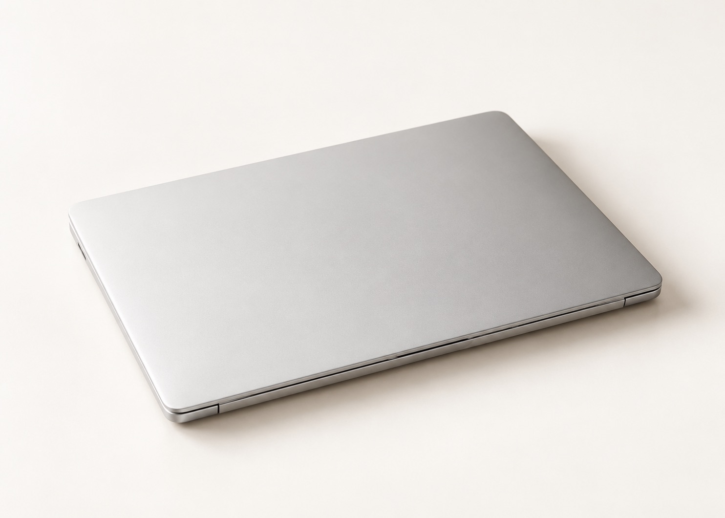 A silver laptop on a warm ivory surface, representing local AI on your Mac